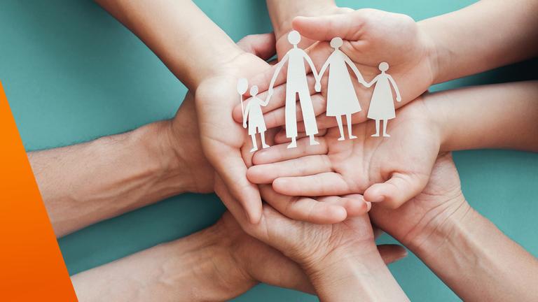 Familie legt Hände ineinander. Hände groß im Bild.