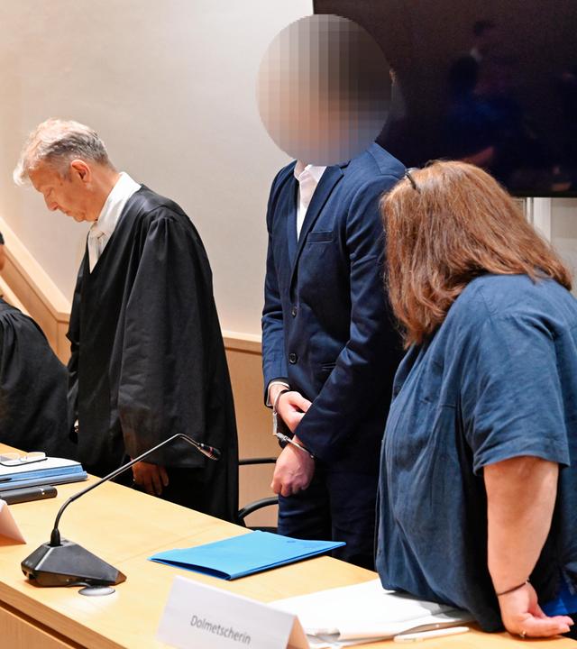 Rheinland-Pfalz, Zweibrücken: Der Angeklagte (2.v.r.) steht neben seinen Anwälten und der Dolmetscherin im Verhandlungssaal des Landgerichts.