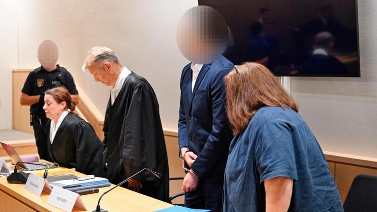 Rheinland-Pfalz, Zweibrücken: Der Angeklagte (2.v.r.) steht neben seinen Anwälten und der Dolmetscherin im Verhandlungssaal des Landgerichts.