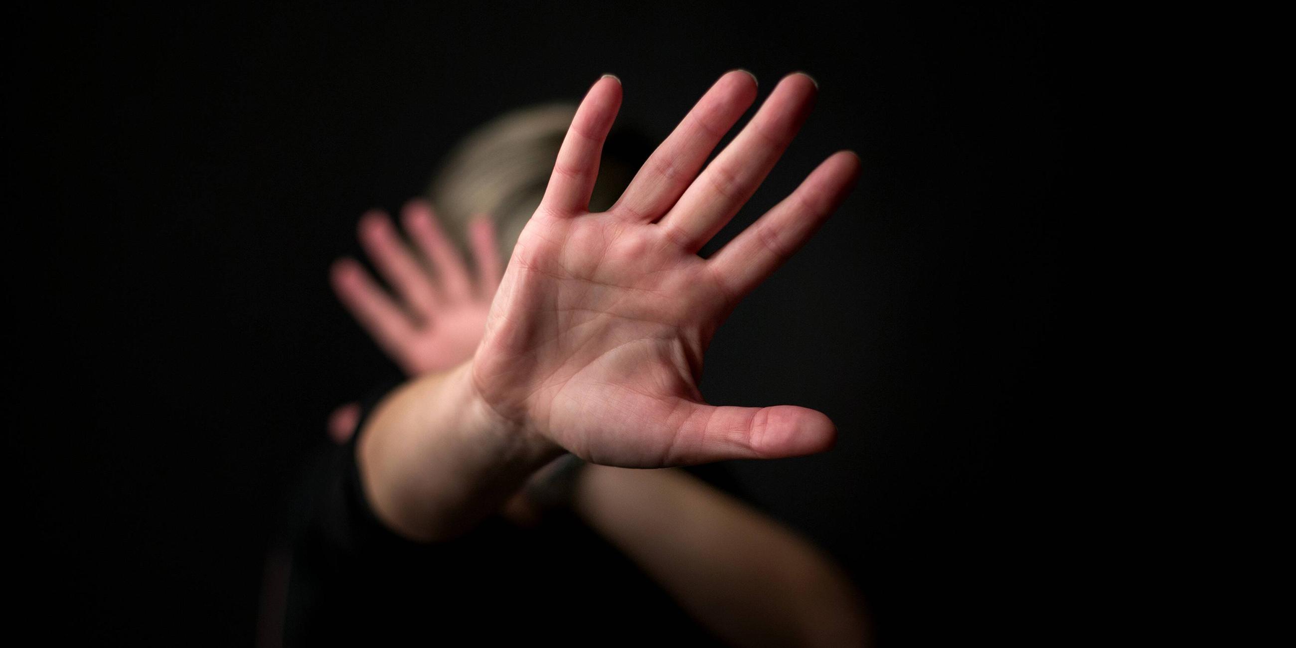 Frau wehrt mit der Hand ab