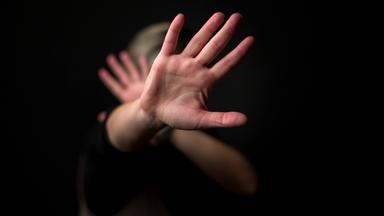 Frau wehrt mit der Hand ab