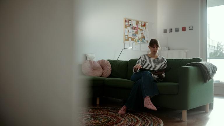 Vera Jansen Wiedenbeck sitzt auf dem Sofa und erinnert sich an die traumatische Geburt ihres Kindes.