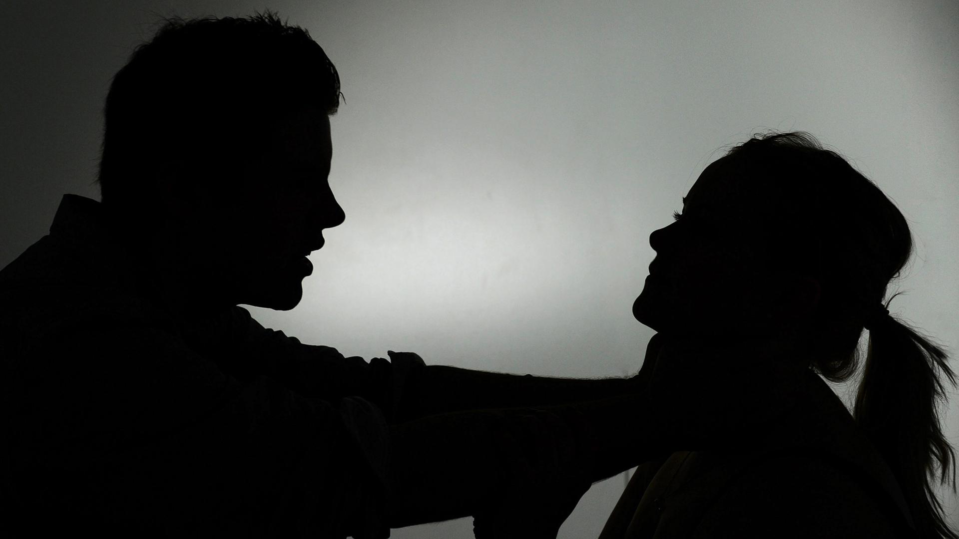 Zwei schwarze Silhouetten: Ein Mann würgt eine Frau