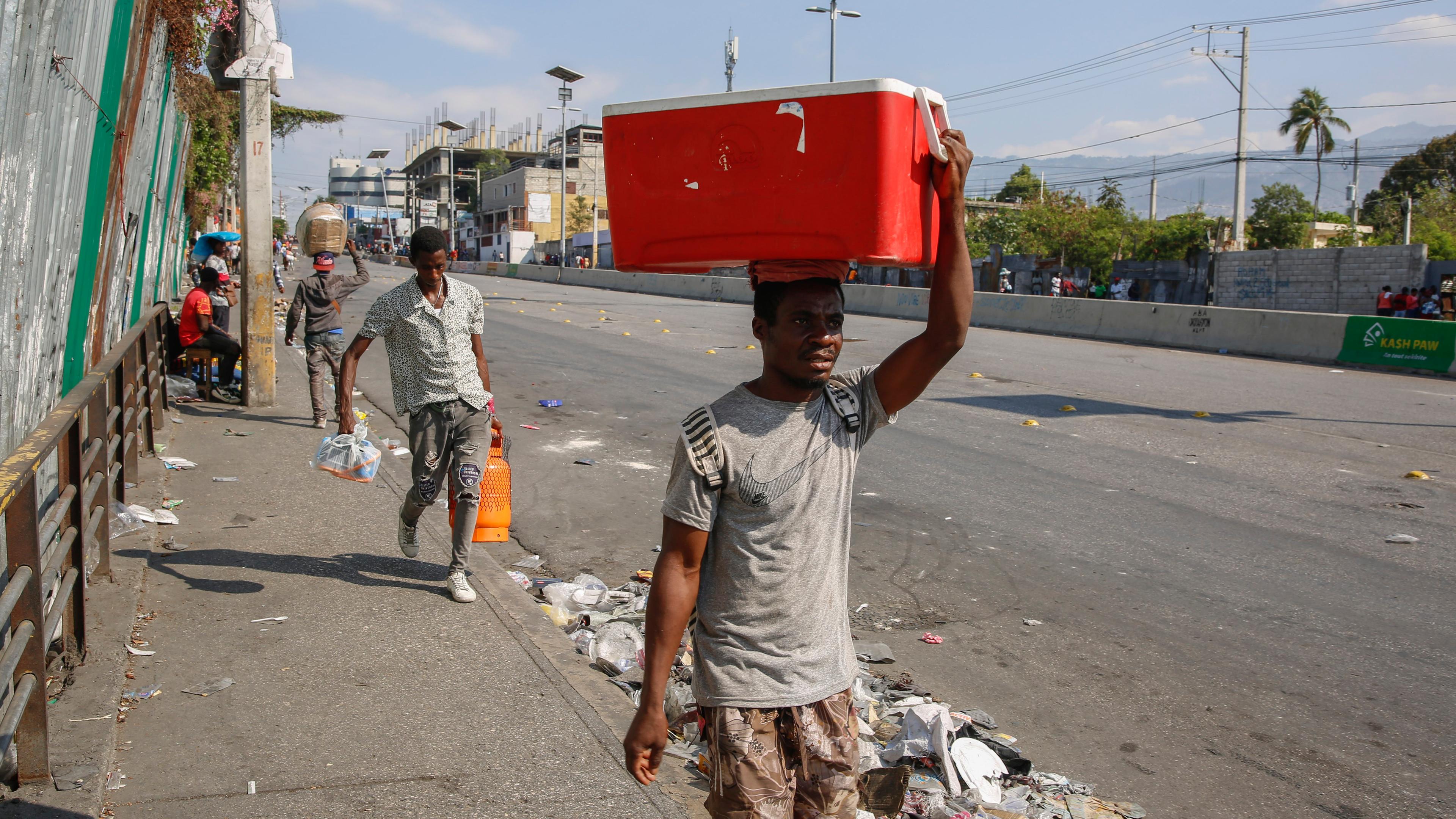 Menschen gehen eine Straße in Port-au-Prince, Haiti, entlang