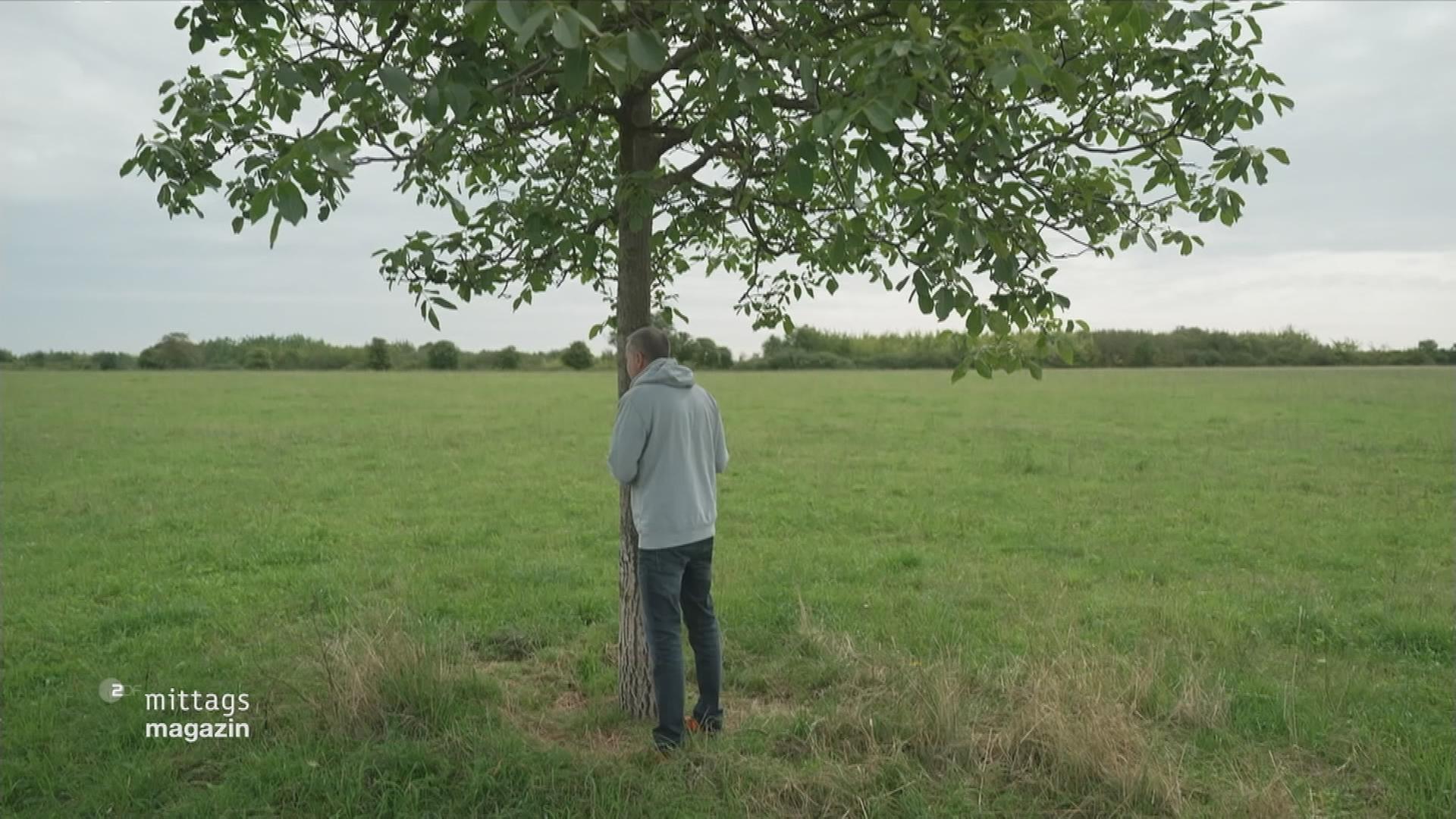 Mensch steht unter Baum