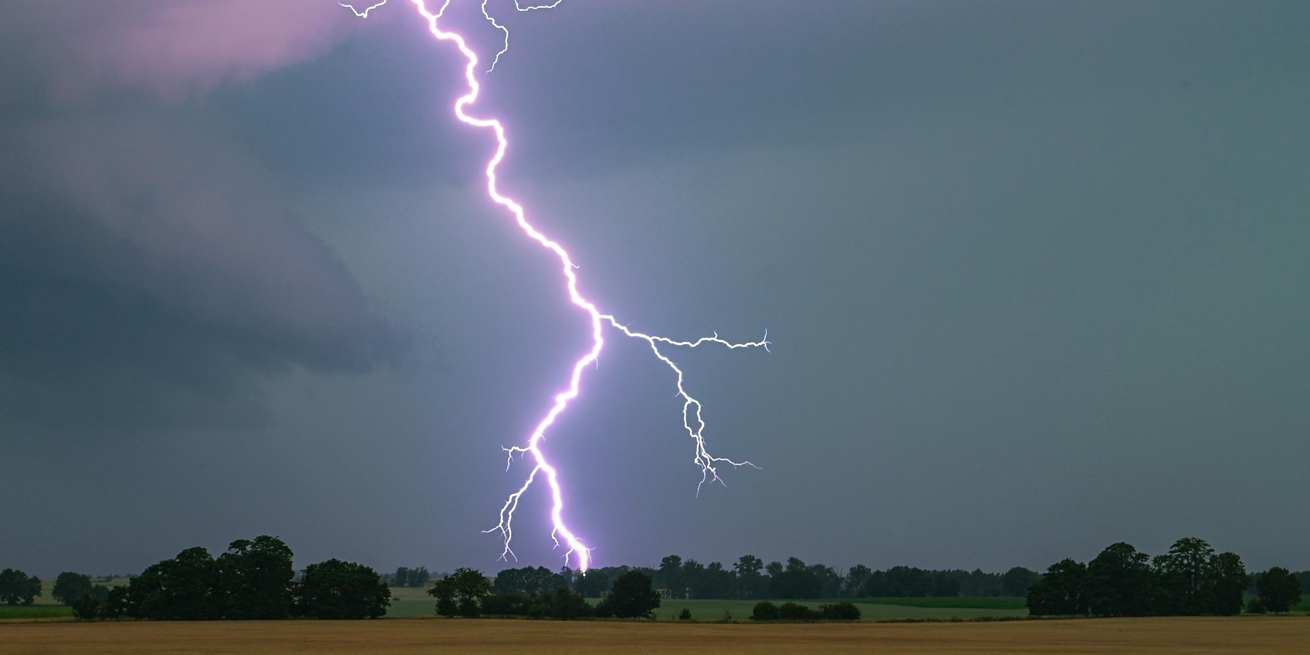 Symbolbild: Ein Blitz leuchtet über einer Landschaft auf.