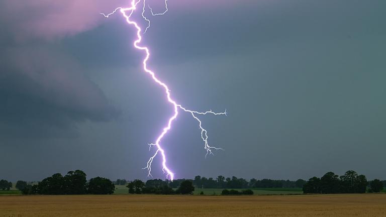 Symbolbild: Ein Blitz leuchtet über einer Landschaft auf. 