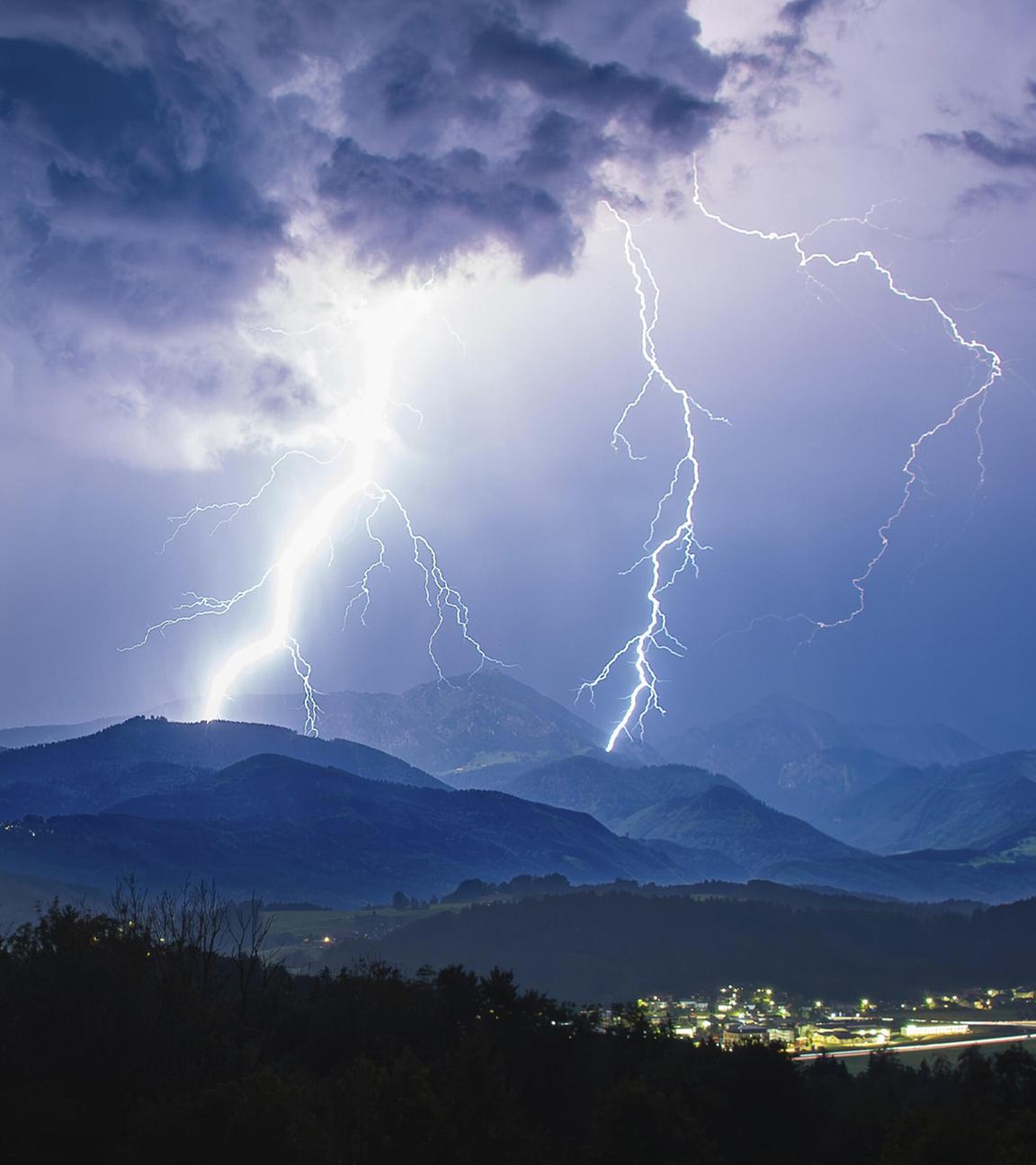 Blitze bei einem heftigen Gewitter über Siegsdorf und dem Hochfelln, Chiemgauer Alpen, Bayern, Deutschland aufgenommen am 28.08.2024.