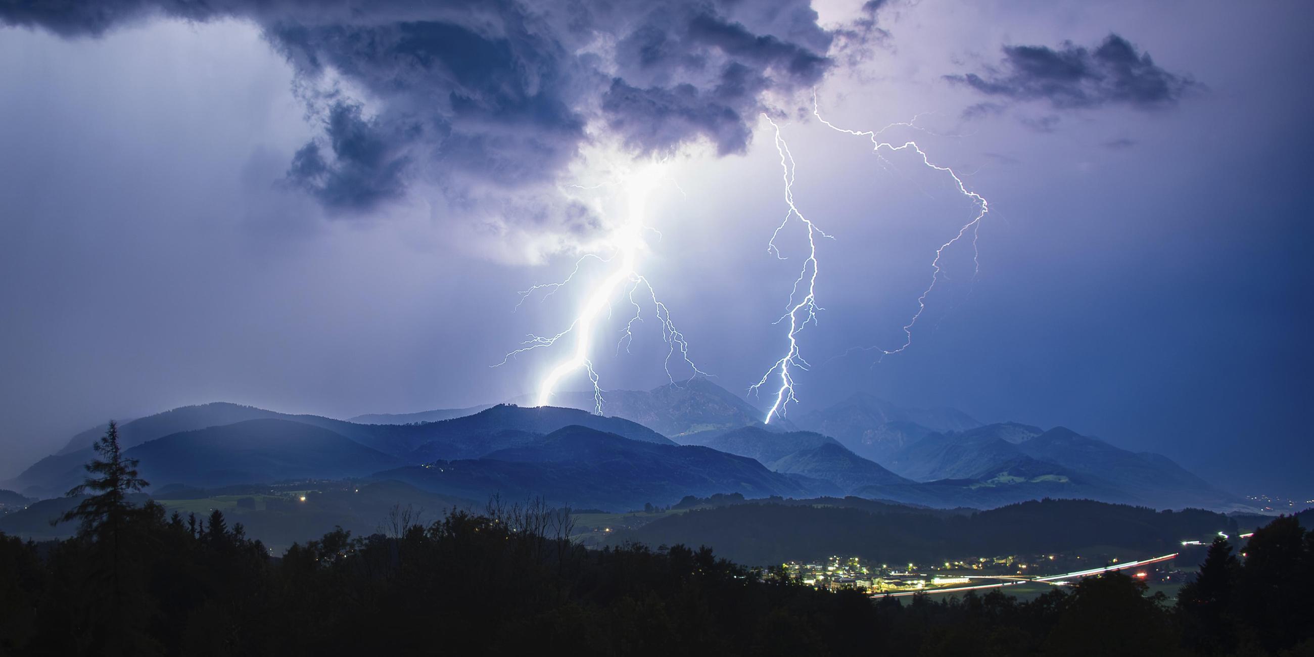 Blitze bei einem heftigen Gewitter über Siegsdorf und dem Hochfelln, Chiemgauer Alpen, Bayern, Deutschland aufgenommen am 28.08.2024.