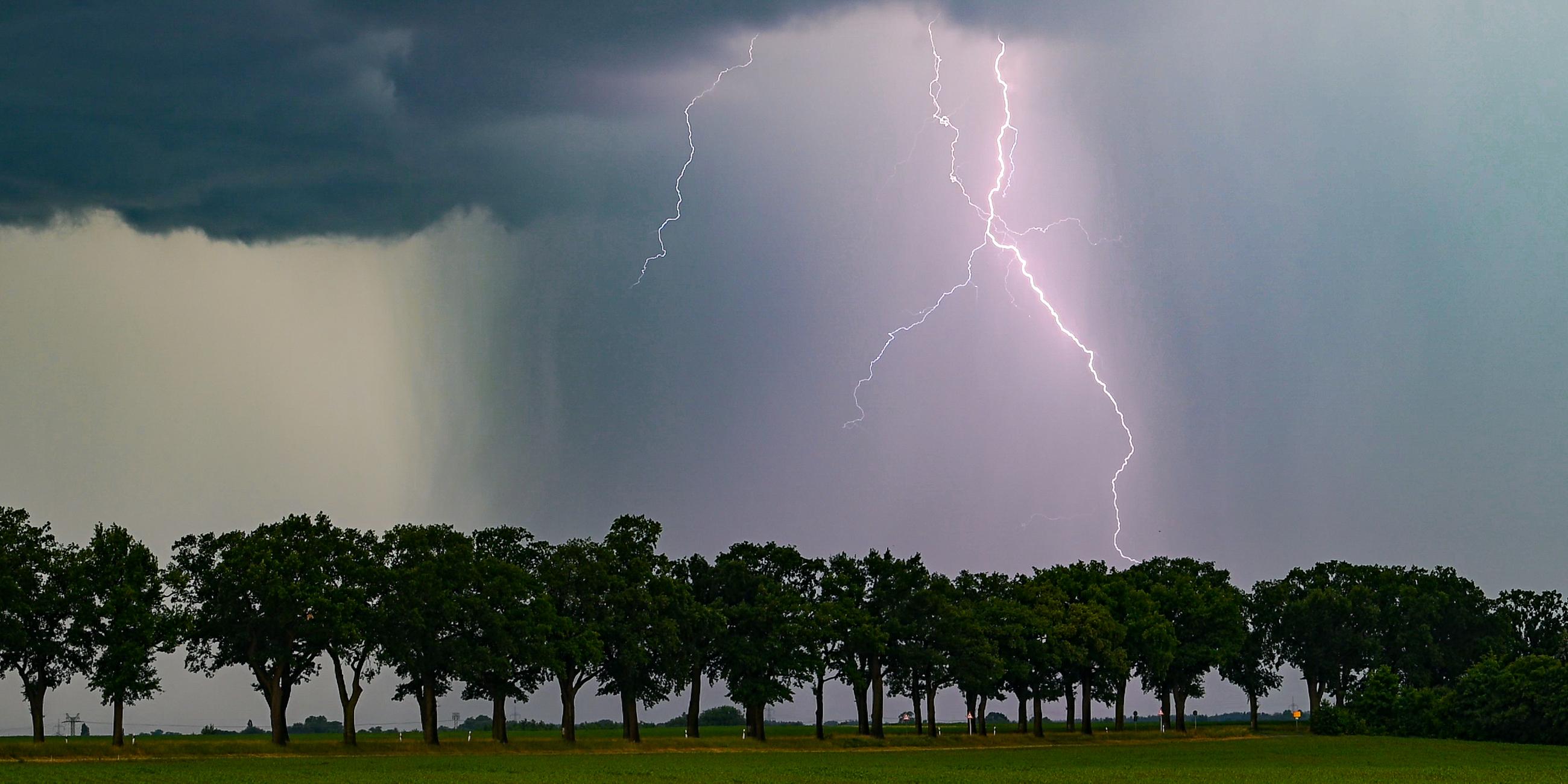 Ein Blitz leuchtet am späten Abend über der Landschaft