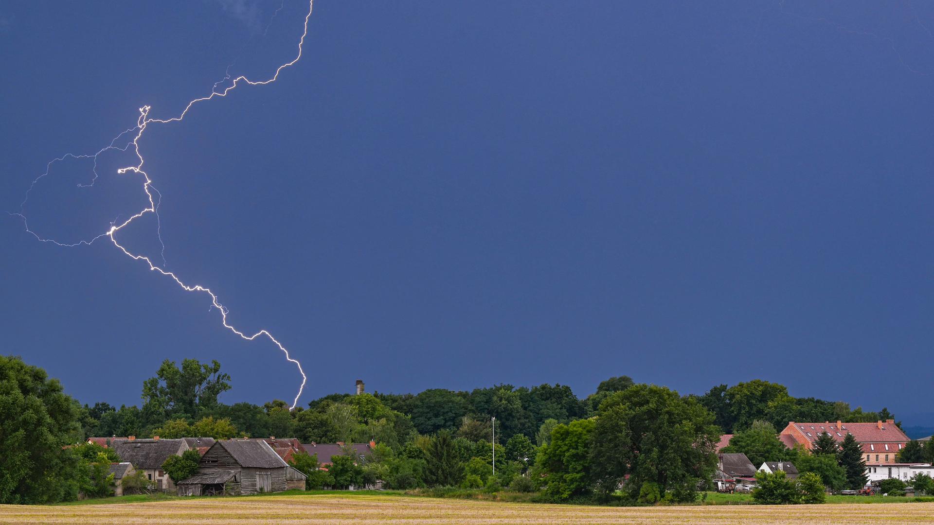 Brandenburg, Petersdorf: Blitze eines Gewitters leuchten über der Landschaft im östlichen Brandenburg.