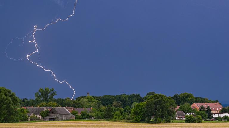 Brandenburg, Petersdorf: Blitze eines Gewitters leuchten über der Landschaft im östlichen Brandenburg.