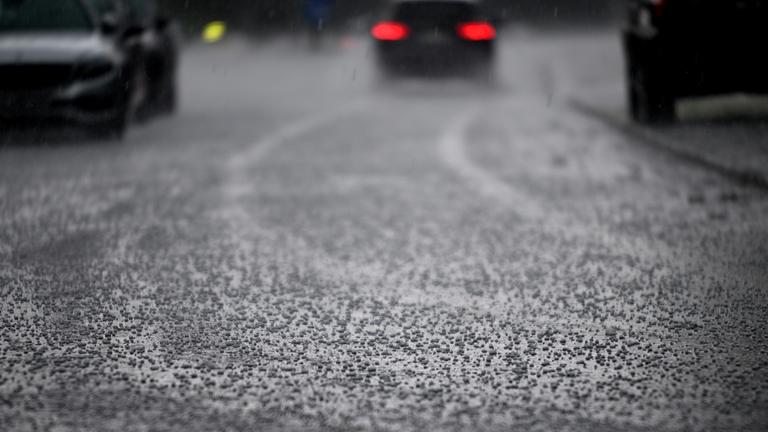 Nordrhein-Westfalen, Köln: Ein Auto fährt durch einen Hagelschauer. Archivbild