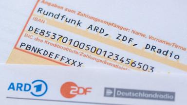 Ein Anschreiben zur Anmeldung für die Rundfunkgebühren liegt auf einem Überweisungsträger.