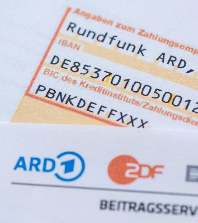Ein Anschreiben zur Anmeldung für die Rundfunkgebühren liegt auf einem Überweisungsträger.