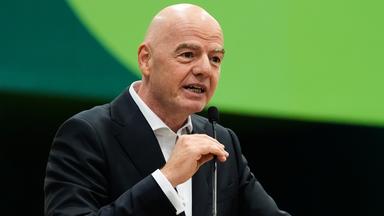 Gianni Infantino spricht in ein Mikrofon vor einem grünen Hintergrund