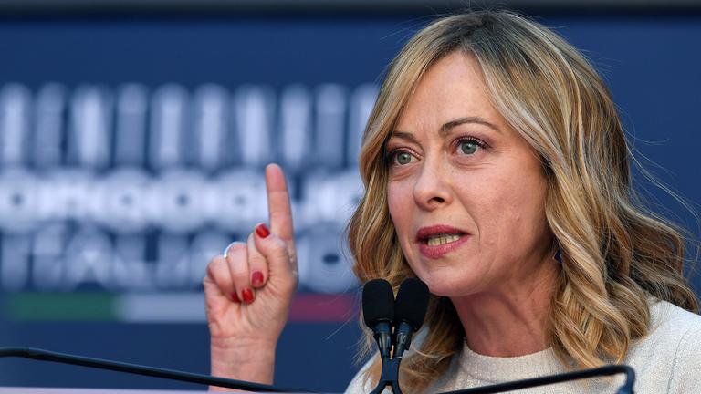 Italienische Regierungschefin Giorgia Meloni hebt den Zeigefinger der rechten Hand.
