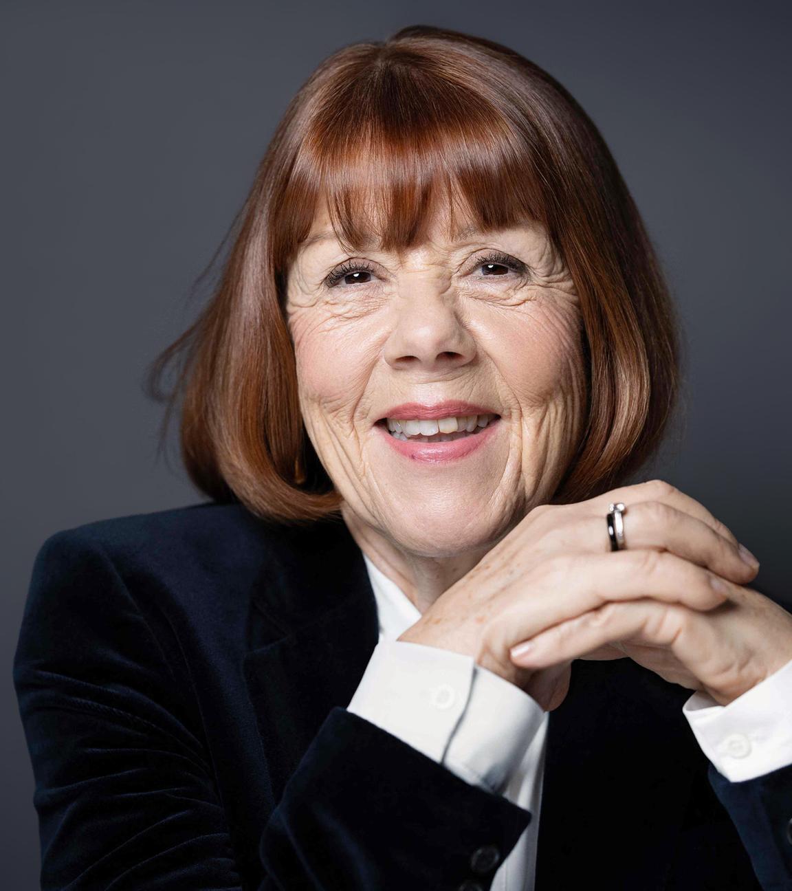 Eine ältere Frau mit Bop-Frisur blickt lächelnd in die Kamera