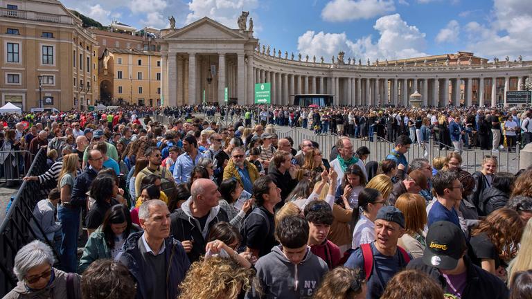 Vatikan, Vatikanstadt: Menschen warten in einer Schlange, um den Petersdom zu betreten, in dem Papst Franziskus seine letzte Ruhe findet.