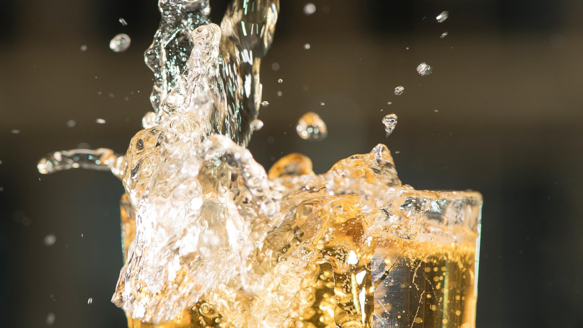 Berlin: Apfelschorle spritzt aus einem Glas.