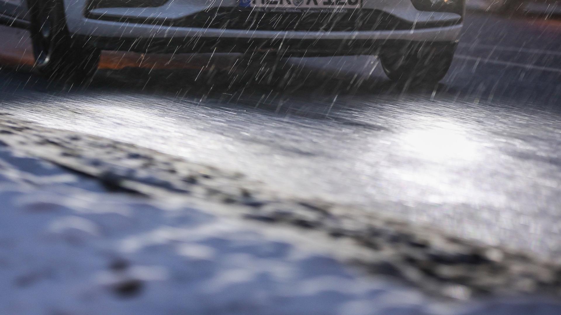  Ein Auto fährt am Morgen bei Regen und Schneeglätte in Richtung Innenstadt in Leipzig