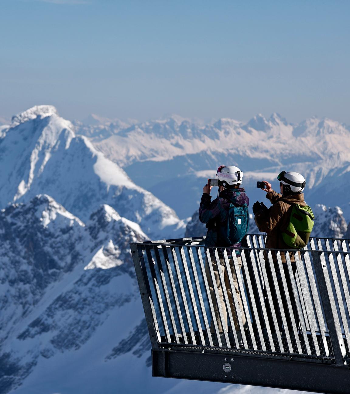Von einem Aussichtspunkt im Skigebiet Zugspitze bei Garmisch-Partenkirchen blicken die Menschen auf die Stelle, wo der Schneefernerkopf-Lift abgebaut wird.