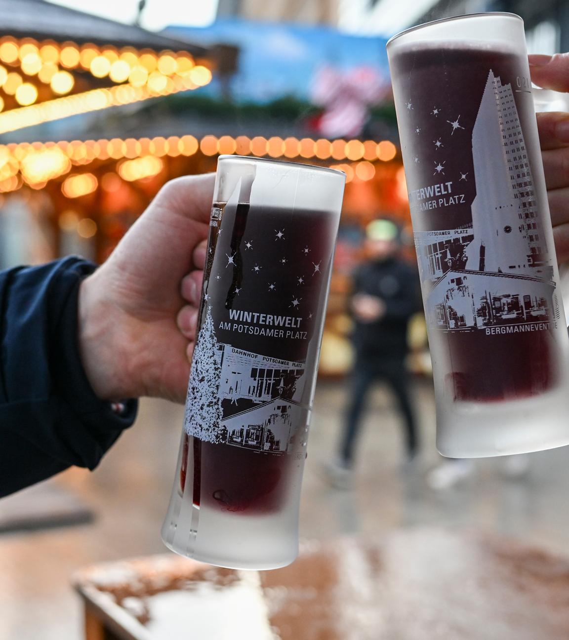 Berlin: Mit zwei Gläsern Glühwein stoßen Besucher vom Weihnachtsmarkt "Winterwelt Potsdamer Platz Berlin" an.
