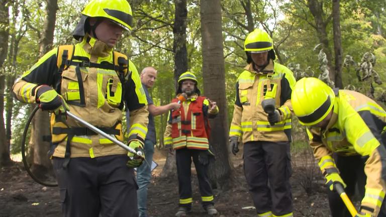 Die Feuerwehr demonstriert ZDF-Reporter Peter Böhmer in der Eifel, wie sie Glutnester löschen.