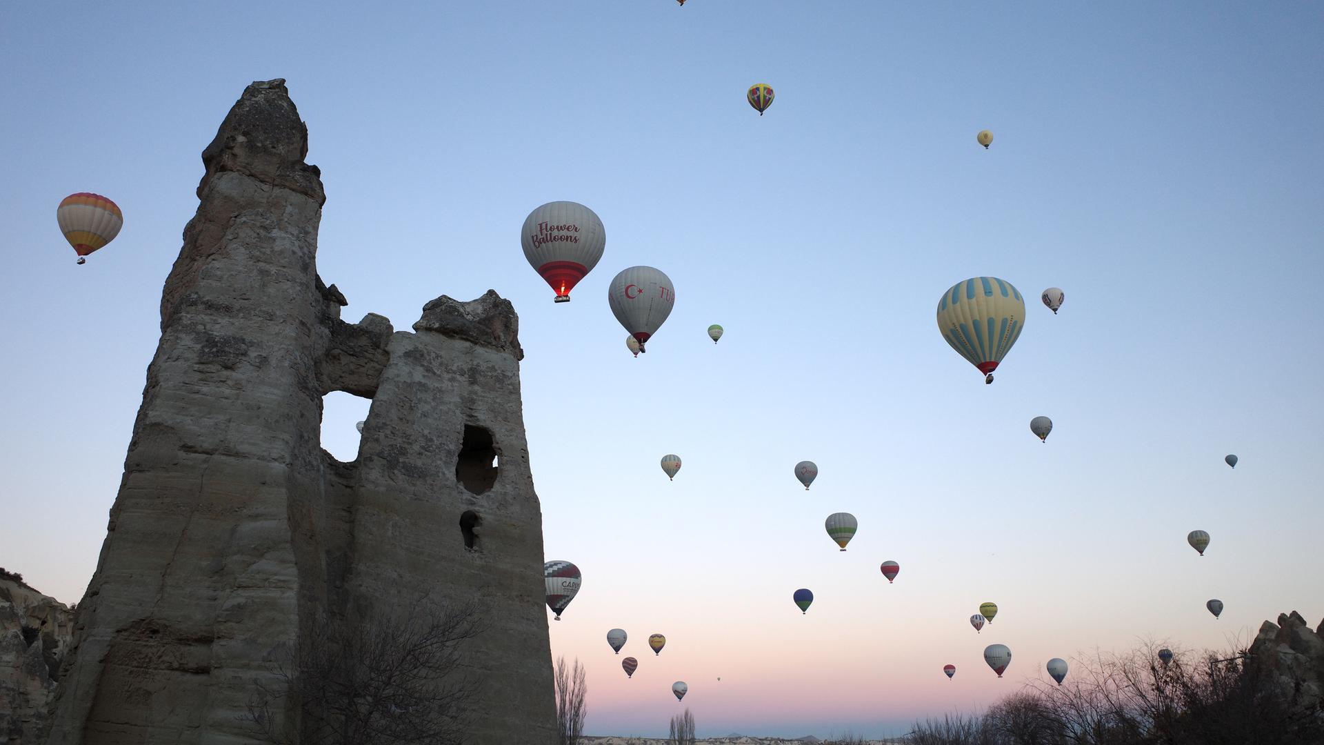Über den Nationalpark Göreme in der Türkei fliegen viele Heißluftballons mit Touristen.