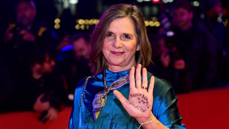 Katrin Göring-Eckardt zeigt ihre Handfläche mit der Aufschrift „Erinnerung ist keine Verletzung“, als sie zur Eröffnungszeremonie der 76. Internationalen Filmfestspiele Berlin eintrifft.