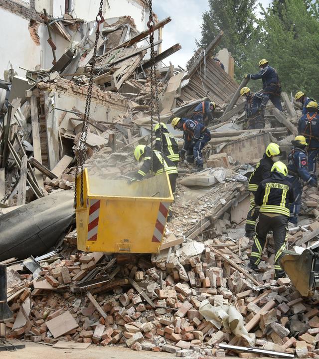 Einsatzkräfte von Feuerwehr und Technischem Hilfswerk arbeiten in den Trümmern eines eingestürzten Gebäudes in Görlitz. 