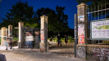 Menschen gehen am Abend nach 23h durch ein offenes Tor im Görlitzer Park, aufgenommen am 01.06.2026