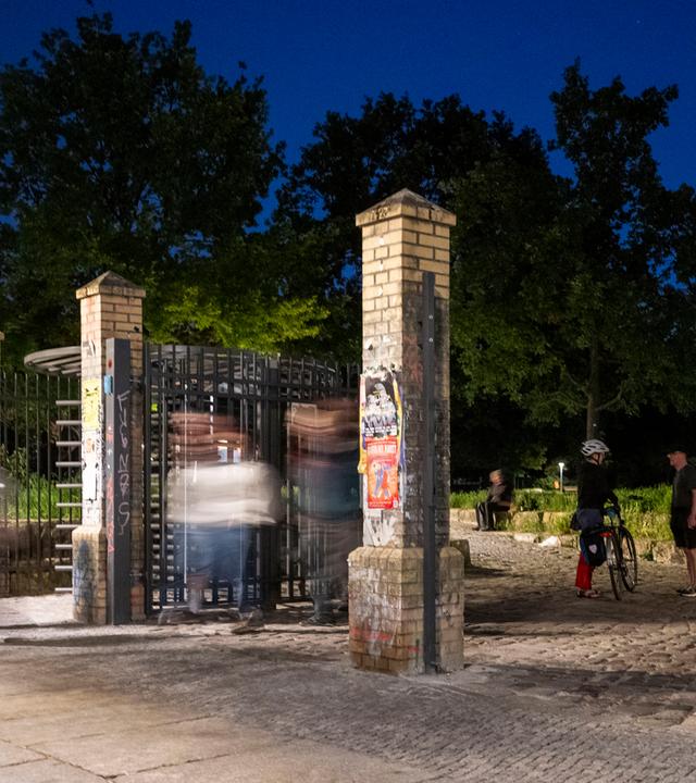 Menschen gehen am Abend nach 23h durch ein offenes Tor im Görlitzer Park, aufgenommen am 01.06.2026