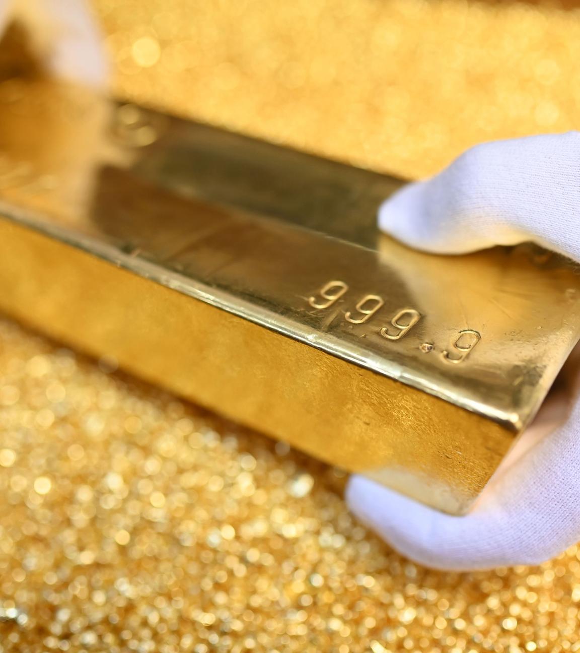 Baden-Württemberg, Pforzheim: Bei der Agosi AG in Pforzheim wird ein Goldbarren gezeigt, der 12,5 Kilogramm (400 Unzen) wiegt, einen Feingoldgehalt von 99,99 Prozent hat und auf Goldgranalien liegt.
