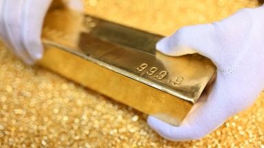 Baden-Württemberg, Pforzheim: Bei der Agosi AG in Pforzheim wird ein Goldbarren gezeigt, der 12,5 Kilogramm (400 Unzen) wiegt, einen Feingoldgehalt von 99,99 Prozent hat und auf Goldgranalien liegt.