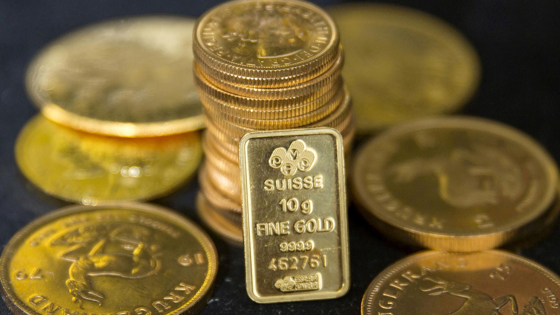 Symbolbild: Goldmünzen und ein Goldbarren