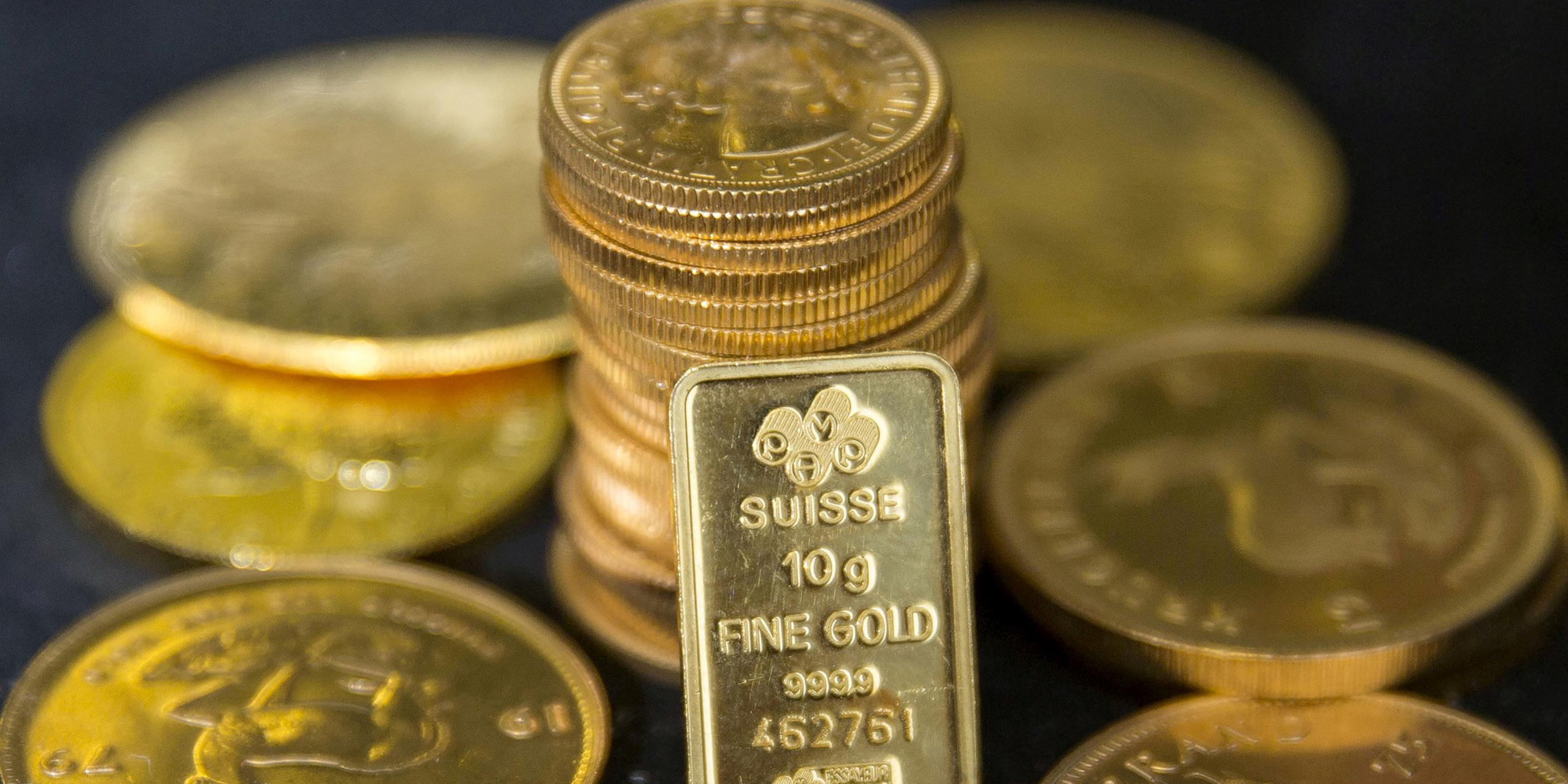 Symbolbild: Goldmünzen und ein Goldbarren