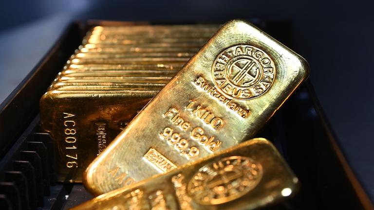 Diverse Goldbarren aufgereiht in einem Tresorraum vom Goldhaus Pro Aurum in München. 