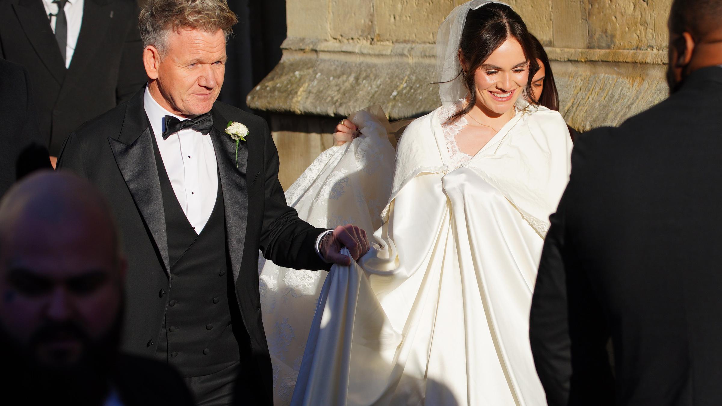 Gordon Ramsay führt seine Tochter Holly durch eine Menge an Fotografen und Gästen.