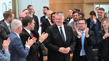 Der neue rheinland-pfälzische Ministerpräsident Gordon Schnieder nach seiner Wahl im rheinland-pfälzischen Landtag in Mainz. Die Personen um ihn herum applaudieren.