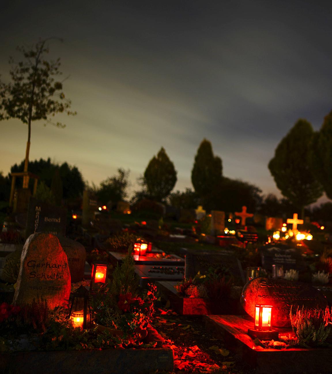 Grablichter auf einem Friedhof an Allerheiligen