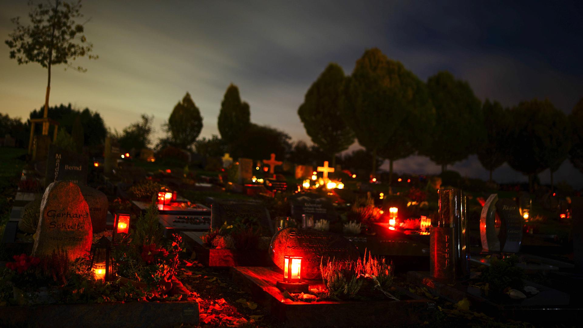 Grablichter auf einem Friedhof an Allerheiligen