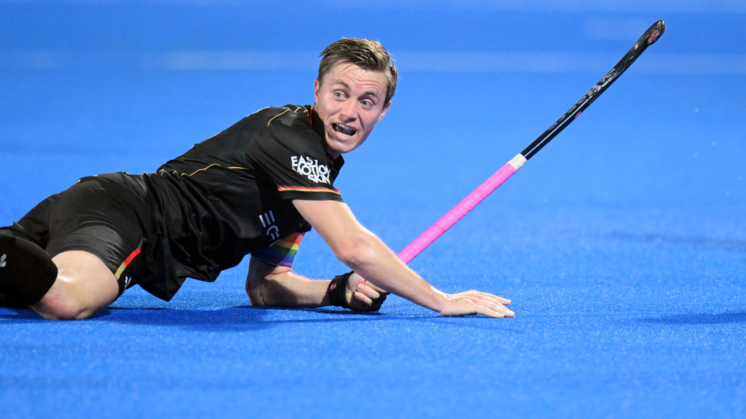 Hockeyspieler Mats Grambusch liegt am Boden des Spielfeldes