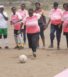 Kenias Fußball-Omas: Mit vollem Einsatz für Gesundheit und Gemeinschaft. Frauen stehen auf einem Feld und eine kickt den Ball.