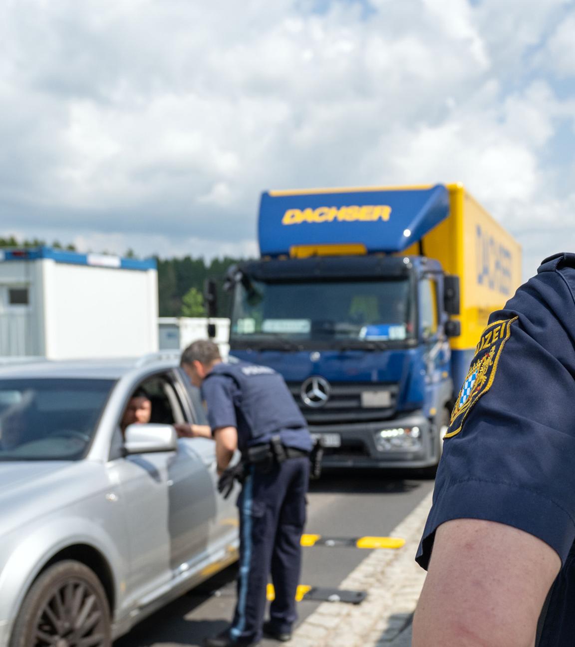 03.06.2025, Wildenau: Ein Polizist überprüft die Dokumente eines Fahrzeugführers im Rahmen einer Grenzkontrolle