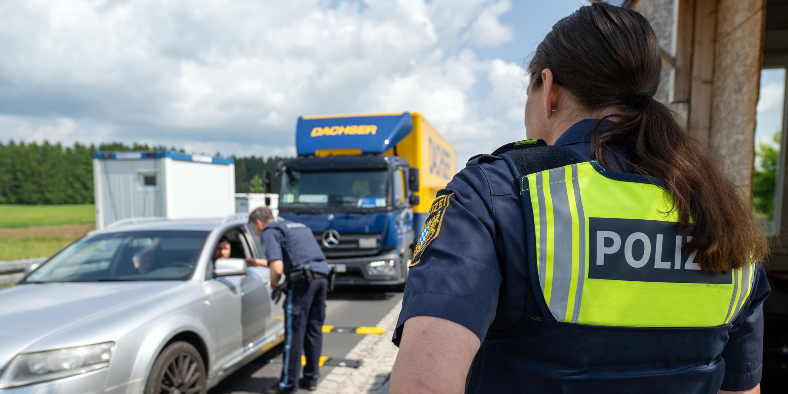 03.06.2025, Wildenau: Ein Polizist überprüft die Dokumente eines Fahrzeugführers im Rahmen einer Grenzkontrolle