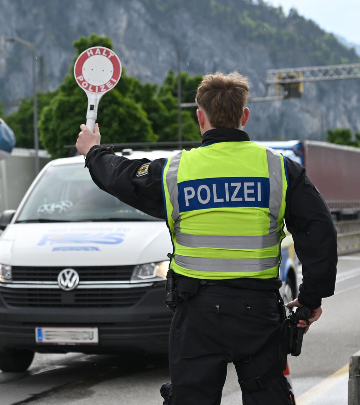 Zwei Beamte der Bundespolizei kontrollieren ein Fahrzeug an einem Grenzübergang entlang der Deutsch-Österreichischen Grenze.