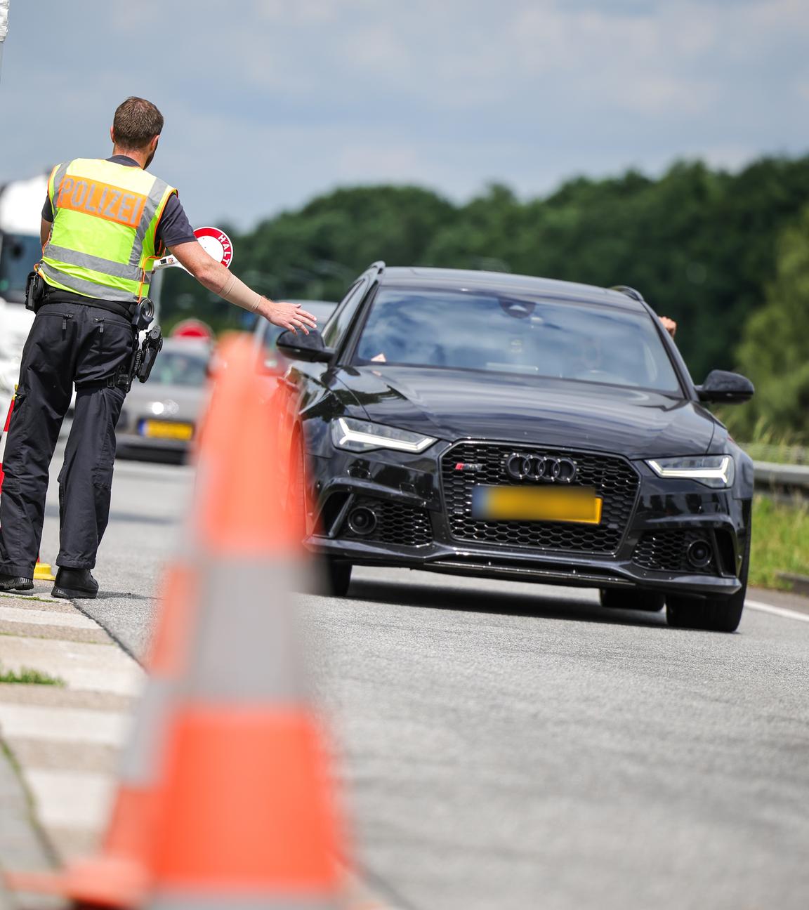 03.06.2025, Nordrhein-Westfalen, Emmerich: An der Grenze zu den Niederlanden auf der A3 in Emmerich kontrollieren zwei Bundespolizisten die nach Deutschland einfahrenden Fahrzeuge.