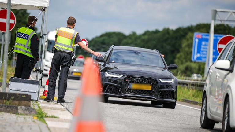 03.06.2025, Nordrhein-Westfalen, Emmerich: An der Grenze zu den Niederlanden auf der A3 in Emmerich kontrollieren zwei Bundespolizisten die nach Deutschland einfahrenden Fahrzeuge.
