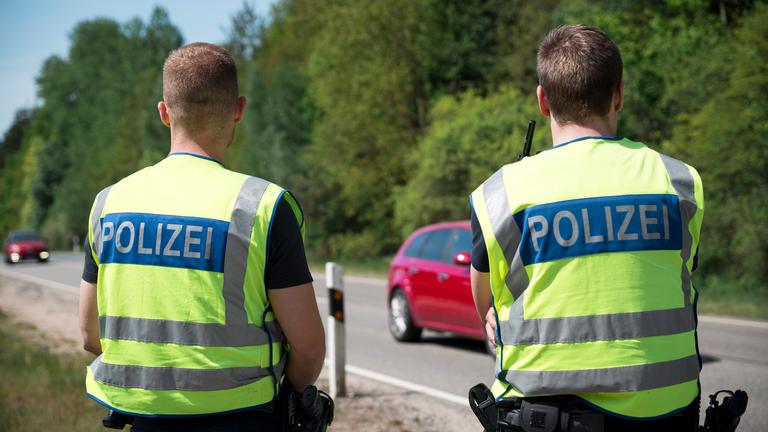 Einsatzkräfte der Polizei stehen an der Grenze zur Tschechischen Republik und überwachen den Verkehr. 